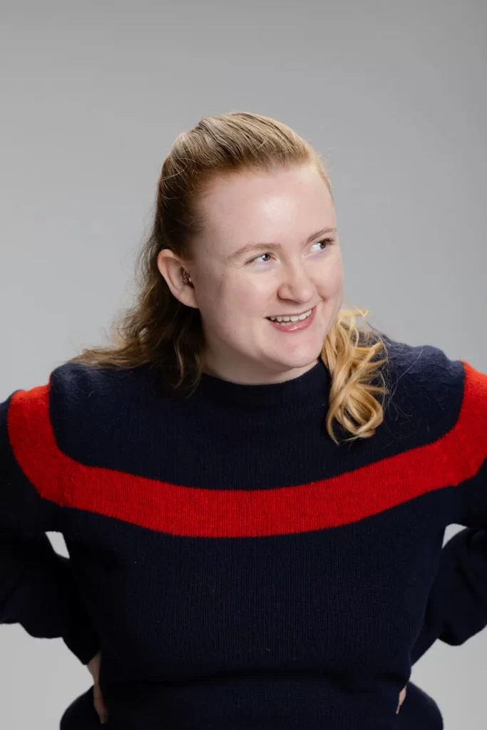 Caitlin Miller wearing a navy jumper with a red stripe, smiling