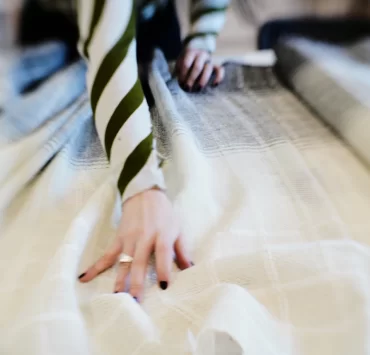 Close-up of hand dyeing a length of woven fabric