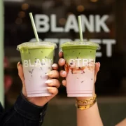 Two hands holding iced matcha drinks from Blank Street Glasgow with branded cups