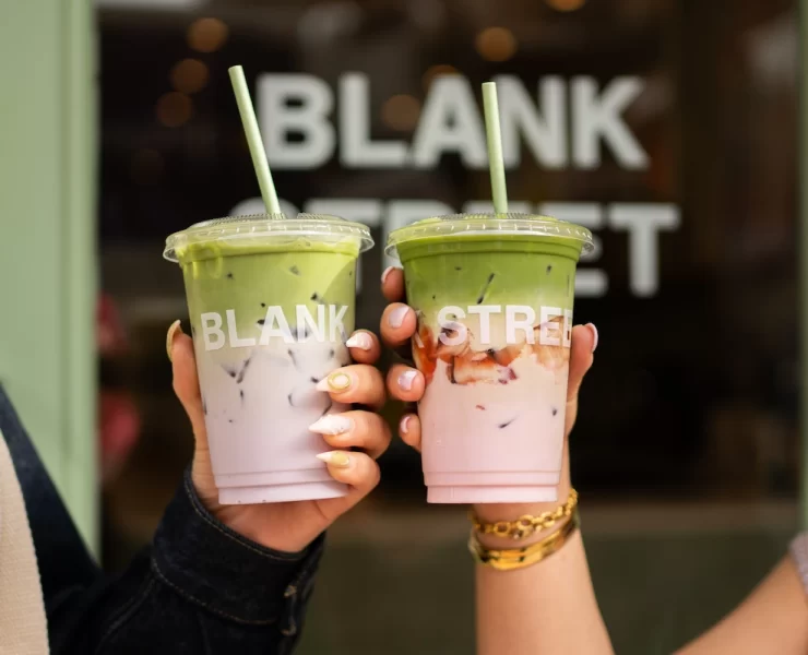 Two hands holding iced matcha drinks from Blank Street Glasgow with branded cups
