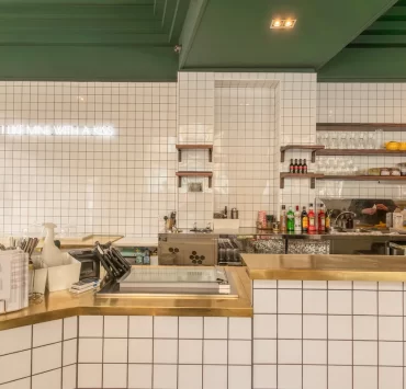 White tiled counter with brass trim at Pantry Bruntsfield