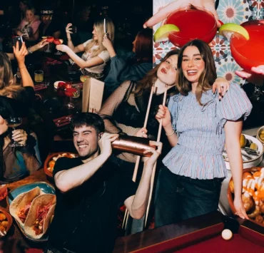 A group of young people enjoying cocktails, Spanish tapas, and socialising at Rioja Glasgow during a lively supper club event.