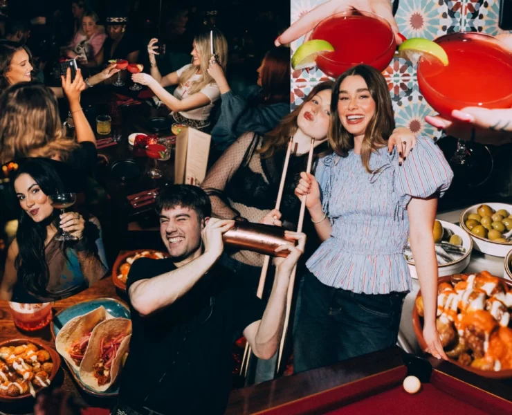 A group of young people enjoying cocktails, Spanish tapas, and socialising at Rioja Glasgow during a lively supper club event.