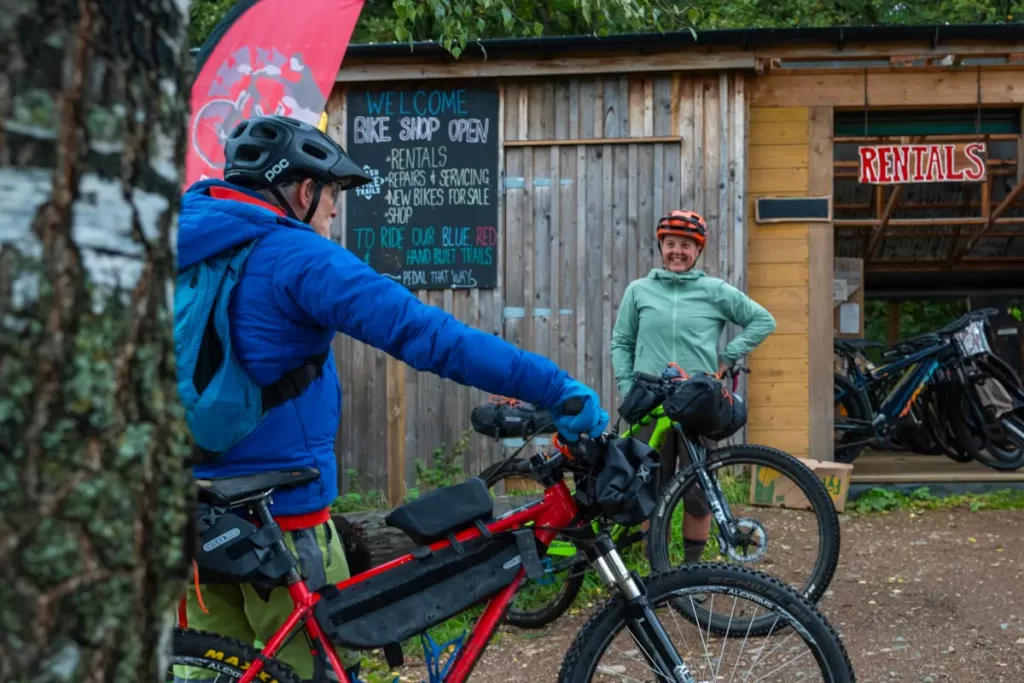 Two cyclists get ready for a bikepacking adventure at Comrie Croft in Perthshire, Scotland.