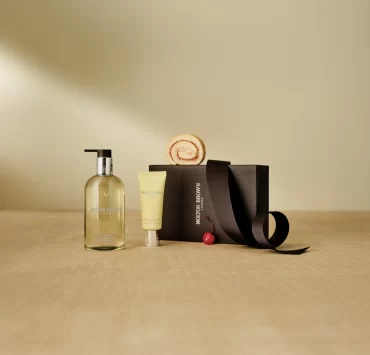 A Molton Brown gift set with hand wash, lotion, and gift box on a neutral background.
