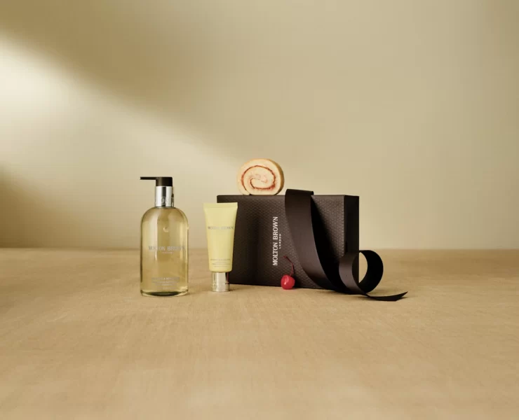 A Molton Brown gift set with hand wash, lotion, and gift box on a neutral background.