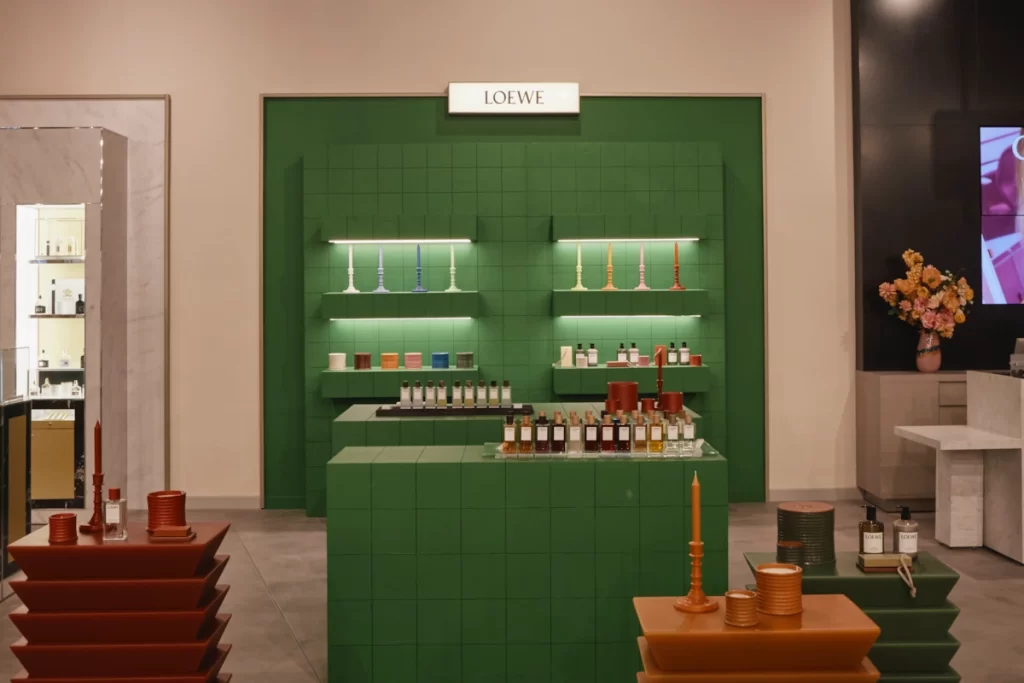 Loewe fragrance display with green tiled walls and colourful perfume bottles at H beauty Silverburn