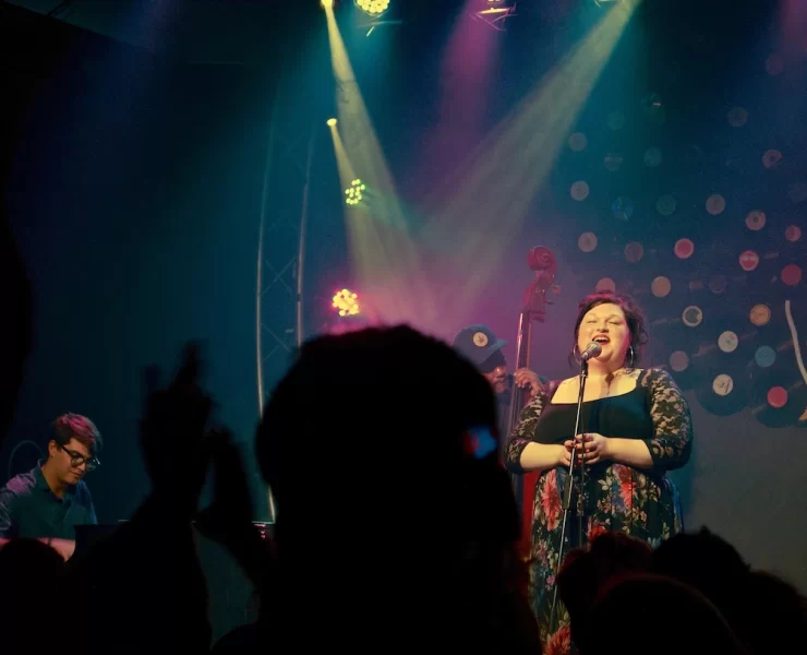 Marianne singing on stage under warm lighting with jazz band behind her