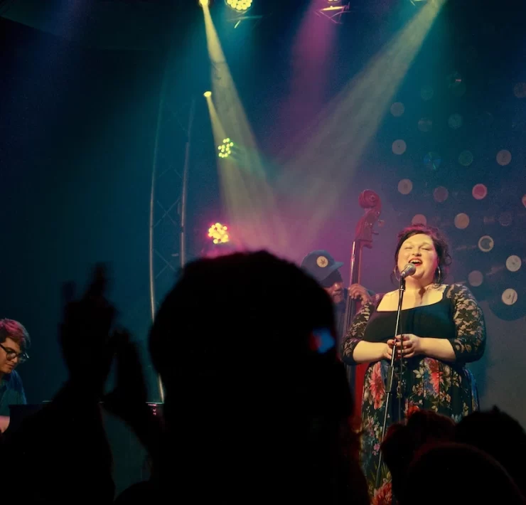Marianne singing on stage under warm lighting with jazz band behind her