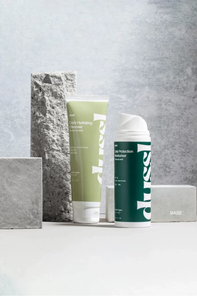 Dussl’s Base Skincare Set with cleanser and moisturiser styled on a minimalist stone background.