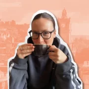 Amyricano TikTok creator holding a coffee cup with Edinburgh skyline in the background
