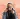 Amyricano TikTok creator holding a coffee cup with Edinburgh skyline in the background
