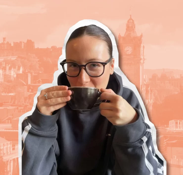 Amyricano TikTok creator holding a coffee cup with Edinburgh skyline in the background