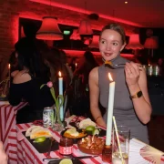 Candlelit table with patatas bravas, paella, tacos and lime wedges.