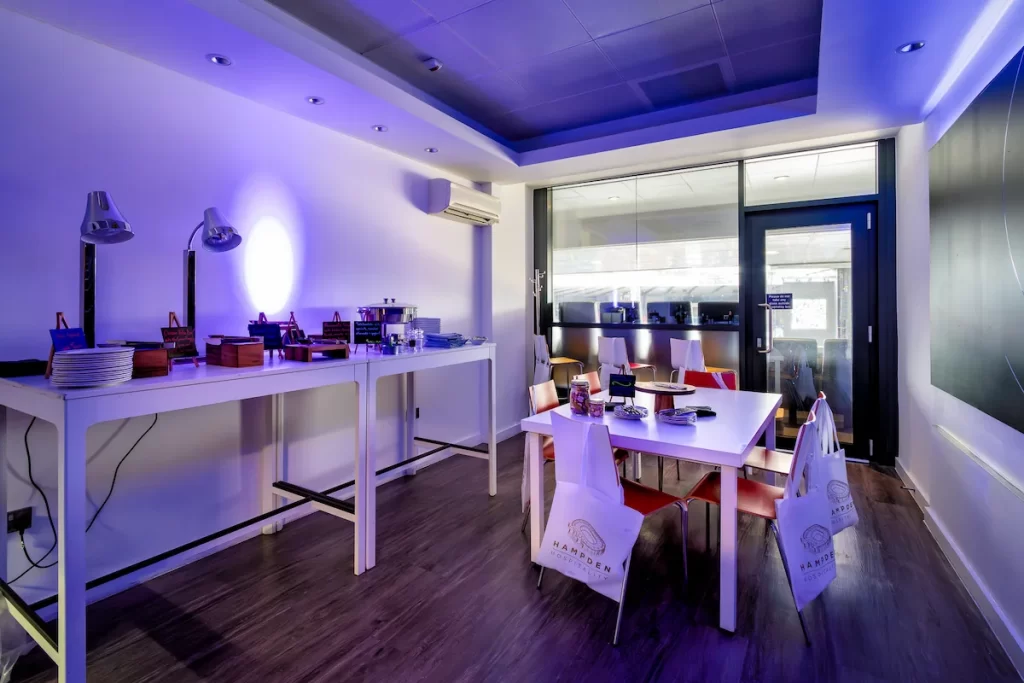 Modern Hampden Park Skybox interior with buffet table and seating area, overlooking the stadium.