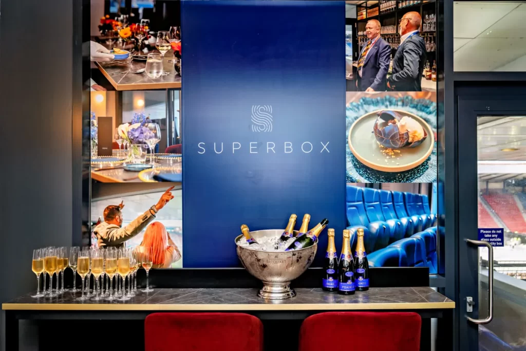 Ice bucket filled with champagne bottles and glasses lined up in Hampden Park Superbox suite.