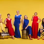 Six women brewers from Scotland pose in bold red, blue and yellow outfits with beer barrels and glasses, marking Lidl’s gender-balanced beer aisle initiative.