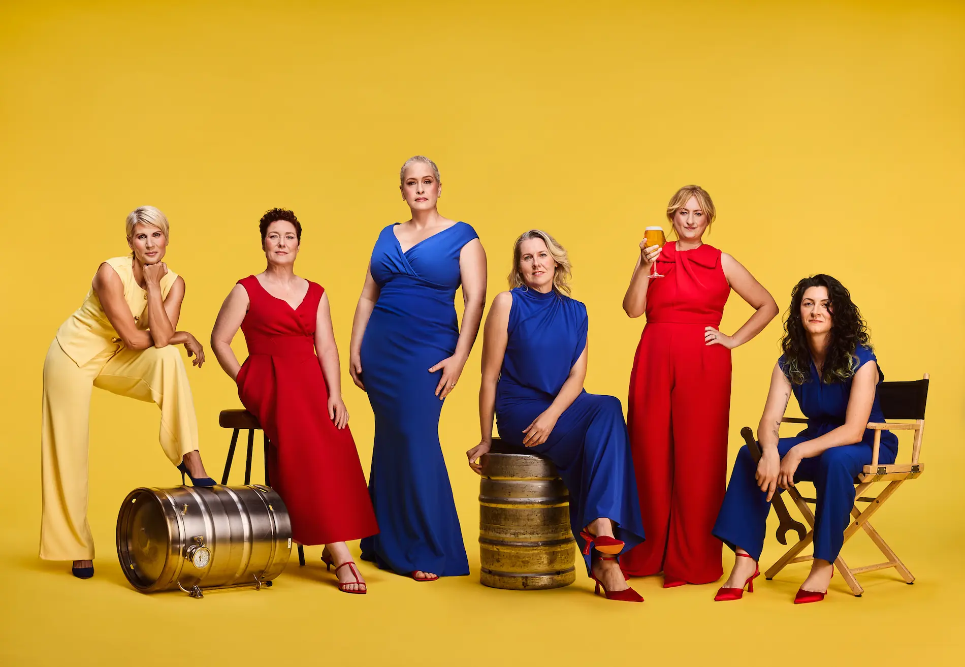 Six women brewers from Scotland pose in bold red, blue and yellow outfits with beer barrels and glasses, marking Lidl’s gender-balanced beer aisle initiative.