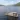 Overhead view of the Taymouth Marina HotBoat floating sauna with guests swimming in Loch Tay, surrounded by rolling hills and open water.