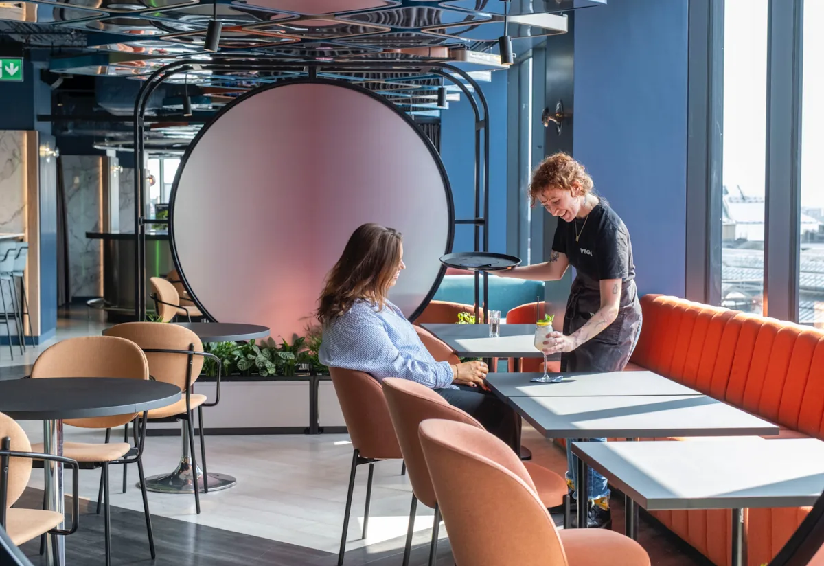 A bartender serves a cocktail to a guest at VEGA Glasgow, the city centre rooftop bar with panoramic views and Glasgow’s first customisable cocktail night out.