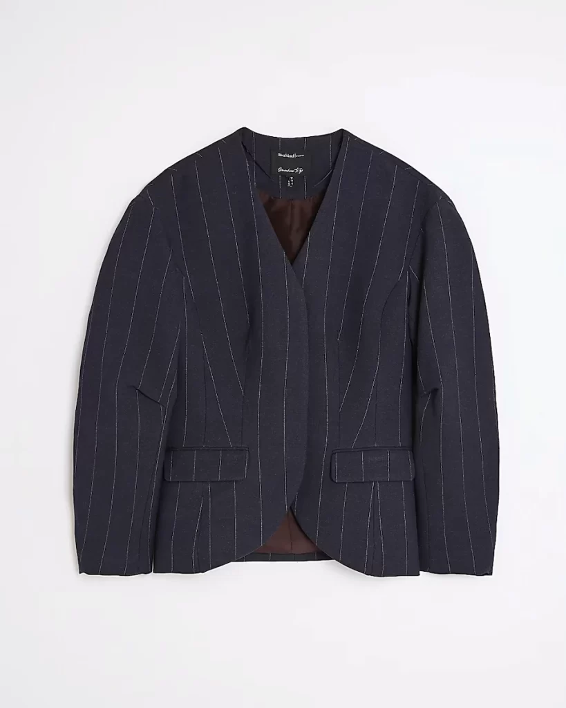Flat lay of River Island’s navy pinstripe cocoon-sleeve blazer with soft tailoring, curved hem and flap pockets, ideal for work or weekend outfits.