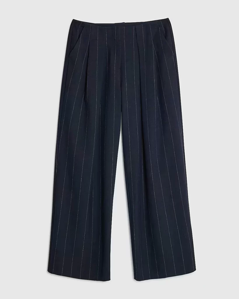 Flat lay of River Island’s navy pinstripe low-waist wide-leg trousers with subtle pleats and a relaxed tailored finish.
