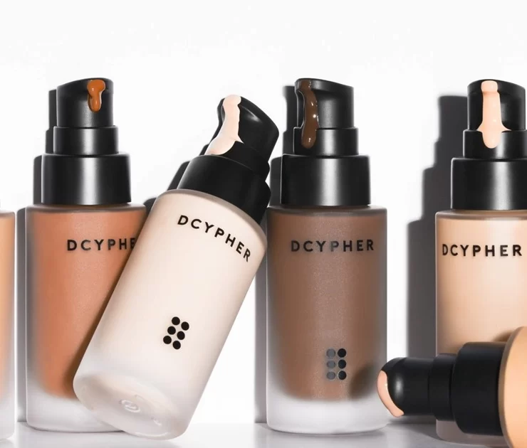 DCYPHER Beauty custom foundation bottles in multiple skin tones with pump applicators.
