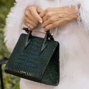 Close-up of the Strathberry Mini Tote bag in green embossed croc leather with gold bar.