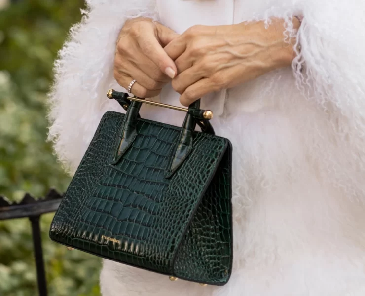 Close-up of the Strathberry Mini Tote bag in green embossed croc leather with gold bar.