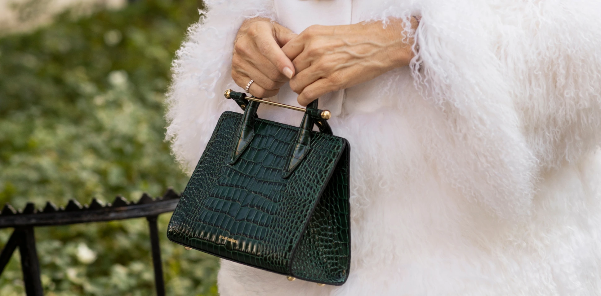 Close-up of the Strathberry Mini Tote bag in green embossed croc leather with gold bar.