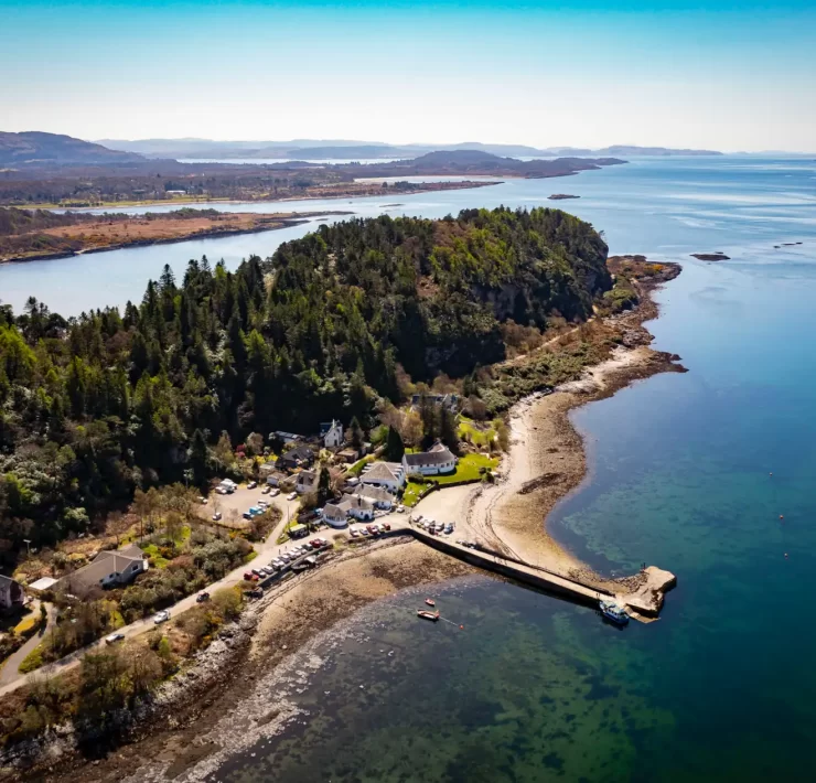 Aerial photograph of The Pierhouse Hotel and Seafood Restaurant in Port Appin, Argyll, surrounded by woodland and overlooking the blue waters of Loch Linnhe.