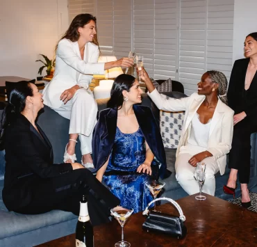 Group of women dressed in Gormley & Gamble tailored suits raising champagne glasses in celebration at Gleneagles Townhouse Edinburgh