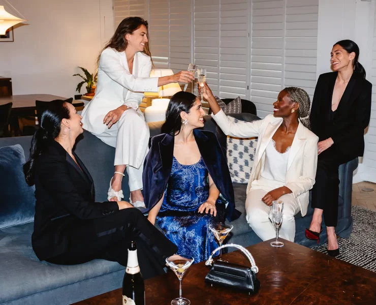 Group of women dressed in Gormley & Gamble tailored suits raising champagne glasses in celebration at Gleneagles Townhouse Edinburgh