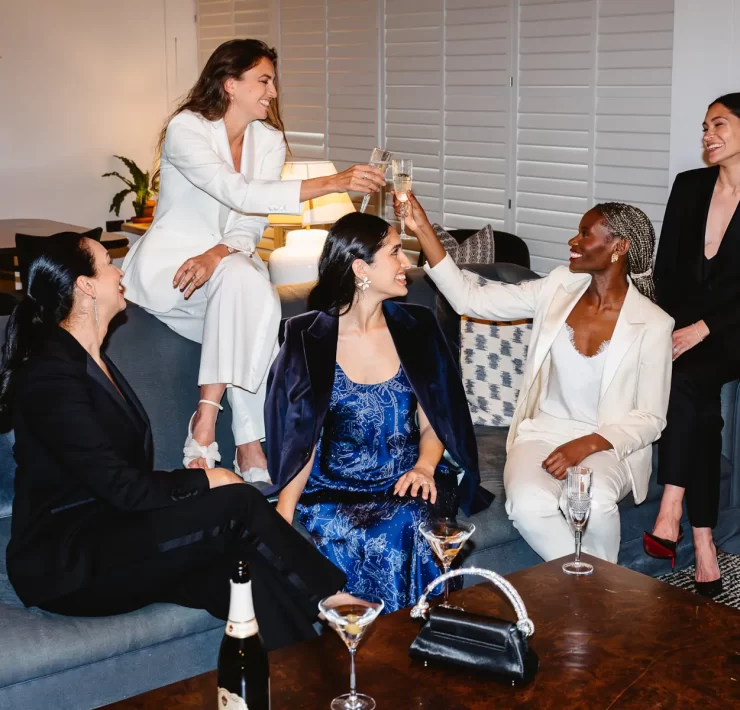 Group of women dressed in Gormley & Gamble tailored suits raising champagne glasses in celebration at Gleneagles Townhouse Edinburgh
