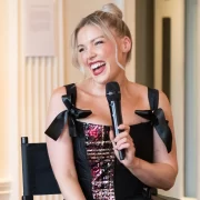 Scottish designer Siobhan Mackenzie smiling and speaking into a microphone during her Blythswood Square Hotel residency launch in Glasgow