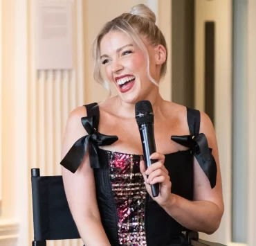 Scottish designer Siobhan Mackenzie smiling and speaking into a microphone during her Blythswood Square Hotel residency launch in Glasgow
