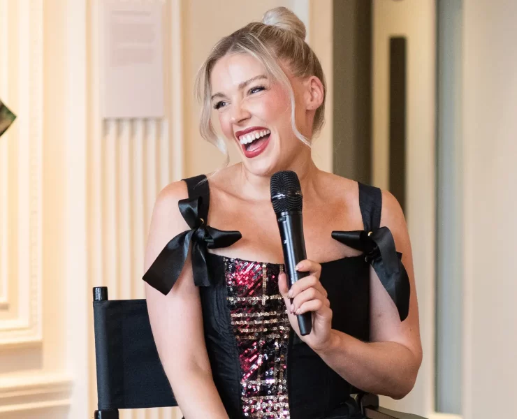 Scottish designer Siobhan Mackenzie smiling and speaking into a microphone during her Blythswood Square Hotel residency launch in Glasgow