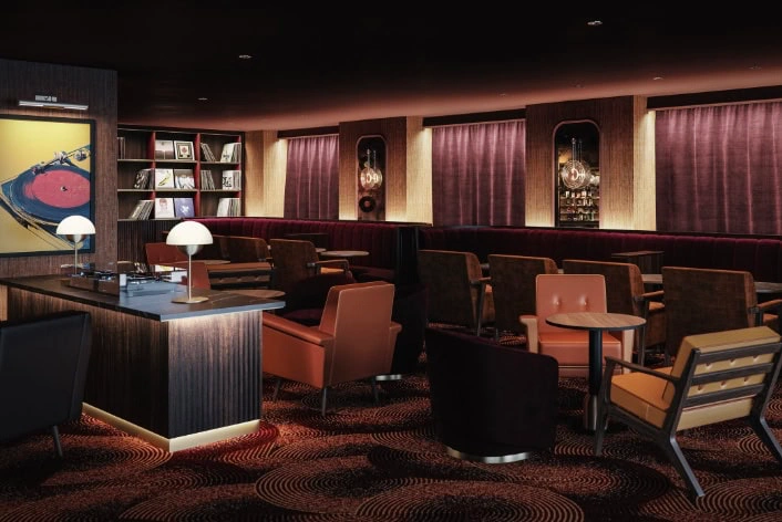 Interior of The Caley Bar in Edinburgh with dark velvet interiors, record collection and cocktail seating.