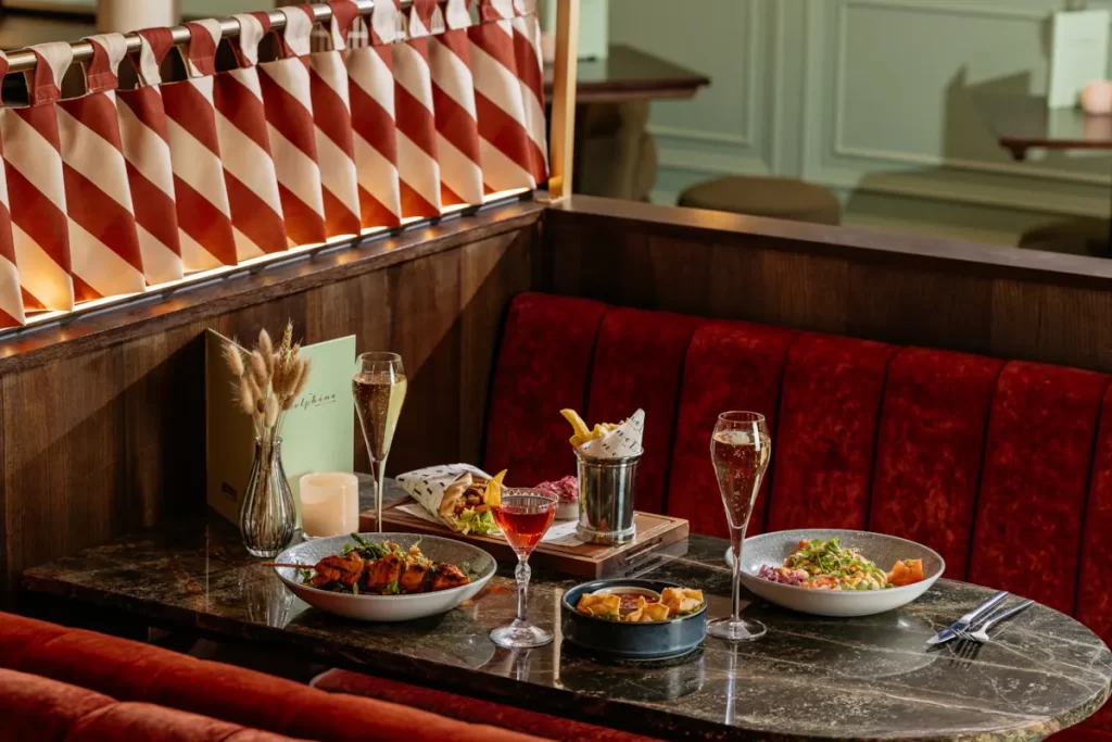 Table setting with cocktails, champagne and small plates at The Delphine restaurant in Princes Square, Glasgow.