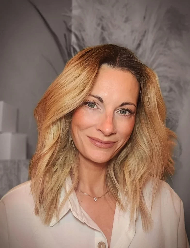 Portrait of Karen Young, founder of rae & daunder, smiling indoors with soft lighting and a neutral background.
