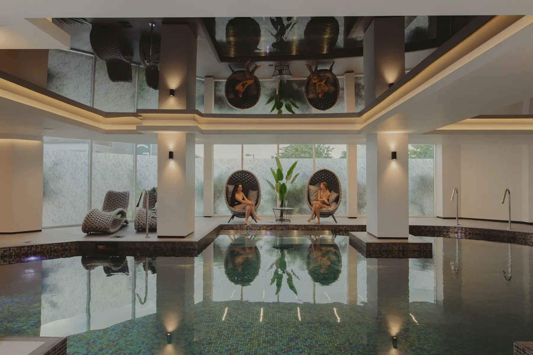 Indoor spa pool with relaxation loungers and seating at The Cairndale Hotel & Spa in Dumfries.