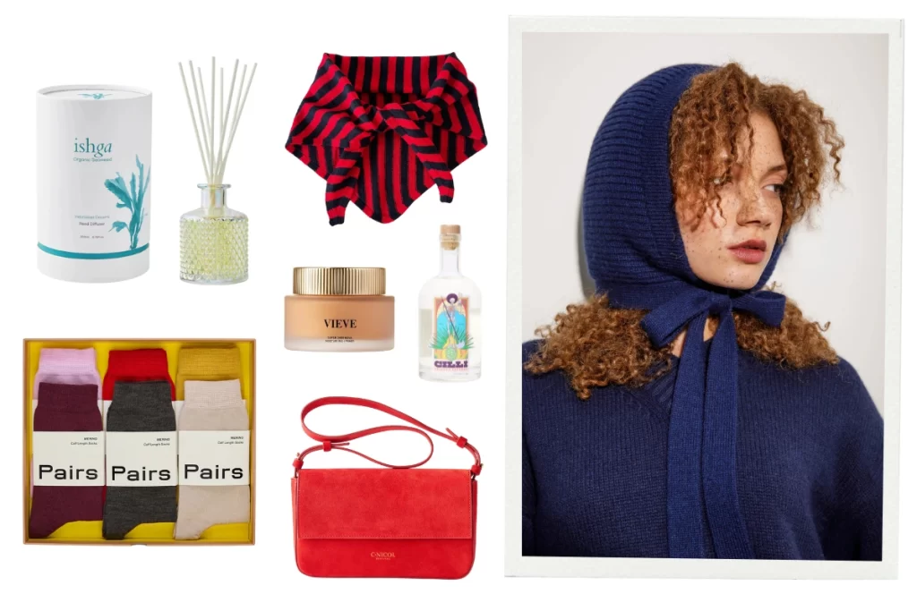 Flatlay of Christmas gift ideas for women, featuring an ishga Hebridean Dreams diffuser, La Fetiche striped lambswool neck scarf, VIEVE Super Skin Nova, Cillí Tequila Picante bottle, Pairs luxury sock set, C.Nicol red suede bag, and a model wearing a navy Kiltane wool hood.