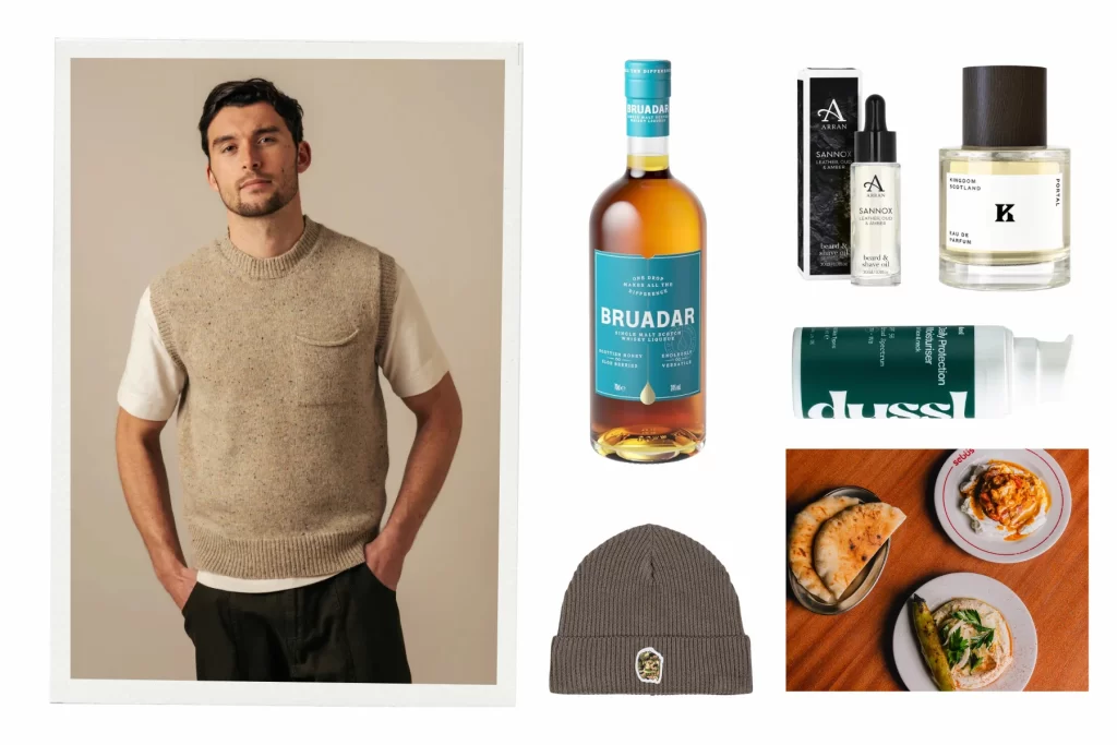A men’s Christmas gift guide flatlay featuring an Eribé knitted vest, a bottle of Bruadar single malt whisky liqueur, Arran Sannox beard and shave oil, Kingdom Scotland Portal fragrance, Dussl moisturiser, a Forty Clothing beanie and small plates from Sebbs restaurant in Glasgow.