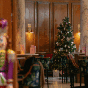 A warmly lit Champagne Central at voco Grand Central Glasgow featuring a decorated Christmas tree, elegant seating and festive décor during the hotel’s seasonal afternoon tea.