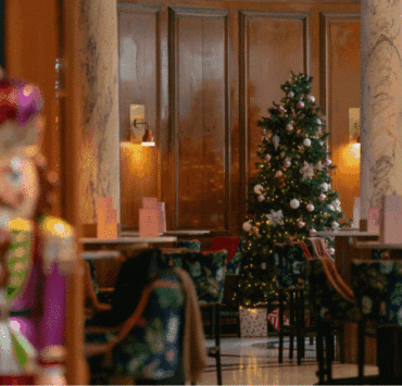 A warmly lit Champagne Central at voco Grand Central Glasgow featuring a decorated Christmas tree, elegant seating and festive décor during the hotel’s seasonal afternoon tea.